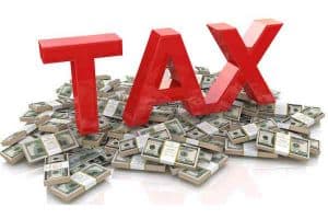the word tax on top of a pile of money