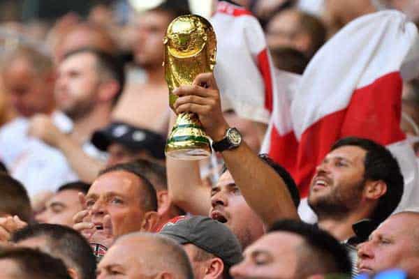 Fans hold the World Cup trophy