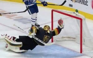 An NHL goalie making a save but the puck is a coronavirus molecule