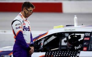 NASCAR driver standing next to car with COVID-19 face mask on