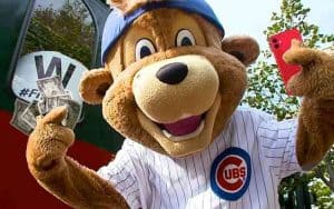 The Chicago Cubs mascot holding an iPhone and some cash
