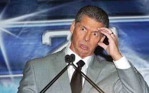 Vince McMahon looking confused with his hand placed on his head