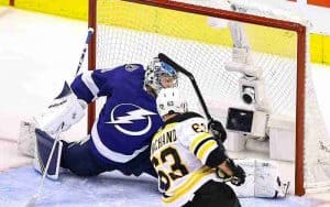 Bruins player shooting the puck against the Lightning goal keeper