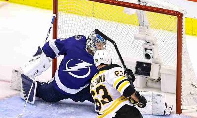 Bruins player shooting the puck against the Lightning goal keeper