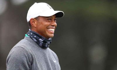 Tiger Woods smiling with a white cap on