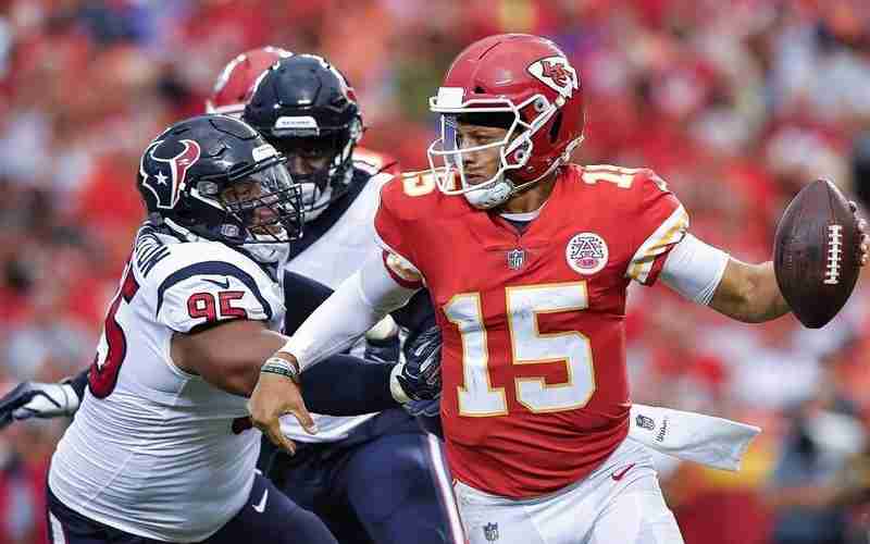 Patrick Mahomes getting tackled by a Texans player