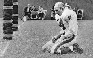 sad quarterback ya tittle kneeling in defeat