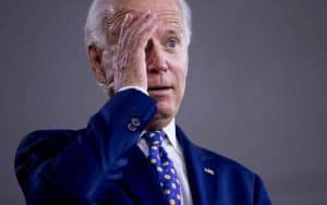 Biden holding his hand to his forehead