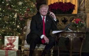 Trump on the phone in front of a Christmas Tree