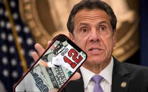 Governor Cuomo holding a smartphone with a mobile sportsbook app pulled up