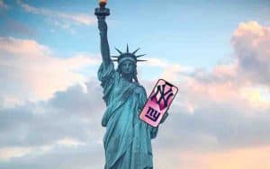 the statue of liberty using a New York sports betting app on her iPhone to bet on the Yankees and Giants NFL odds