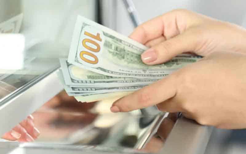 a woman withdrawing cash from a sportbook window