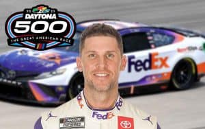 2023 Daytona 500 logo and Denny Hamlin in front of his car