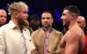 Jake Paul and Tommy Fury facing off in the middle of a boxing ring