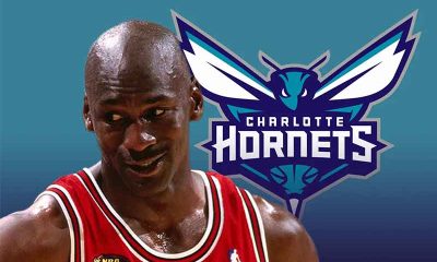 Michael Jordan in front of a Charlotte Hornets logo