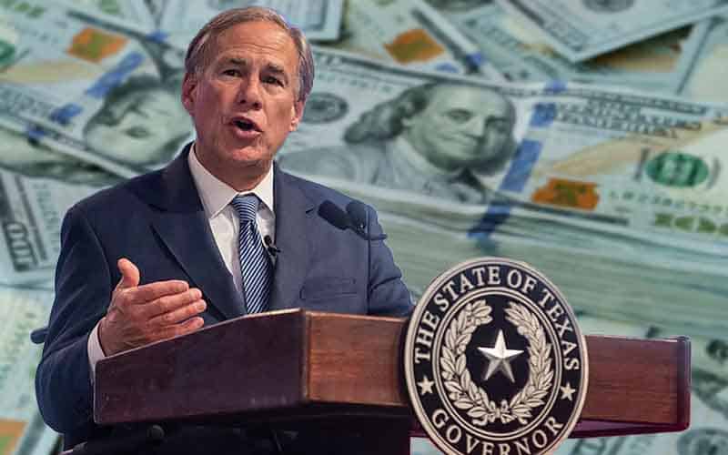 Texas Governor Greg Abbott speaking in front of a large stack of money