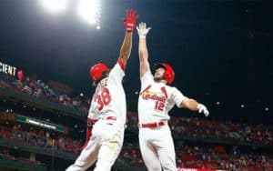 two St. Louis Cardinals players jumping in the air for a high five