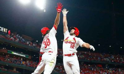 two St. Louis Cardinals players jumping in the air for a high five