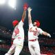 two St. Louis Cardinals players jumping in the air for a high five