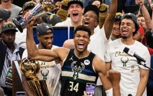Giannis Antetokounmpo hoisting a NBA Championship Trophy
