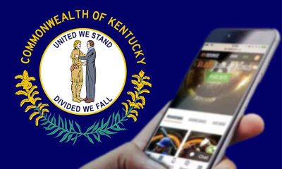 Kentucky state flag with a mobile sports betting app being used in front of it