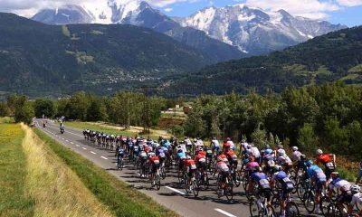 2023 Tour de France competitors racing toward a mountain scape