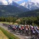 2023 Tour de France competitors racing toward a mountain scape