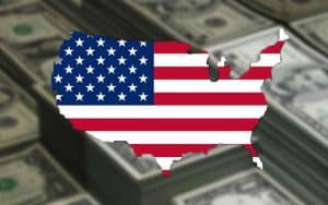an American flag in the shape of the United States in front of stacks of money
