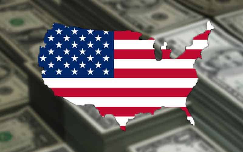 an American flag in the shape of the United States in front of stacks of money