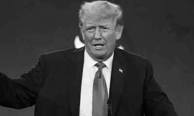 a black and white image of Donald Trump speaking to an audience