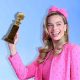 Margot Robbie as Barbie holding a Golden Globe