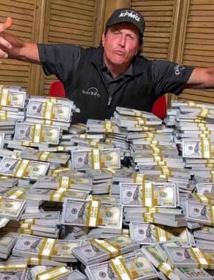 Phil Mickelson acting out in front of a pile of cash