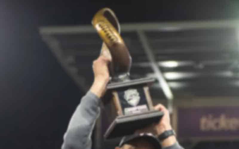 hoisting a championship trophy after a bowl game win