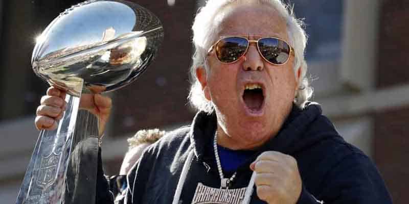Patriots owner Robert Kraft holding a Lombardi and pumping his fist
