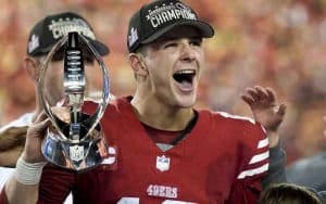 Brock Purdy of the 49ers hoisting the AFC Championship Trophy
