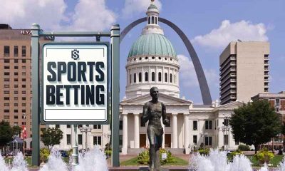 a sports betting sign in front of the St. Louis Arch