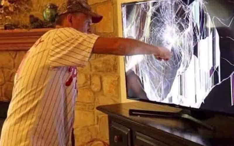 a man punching a television