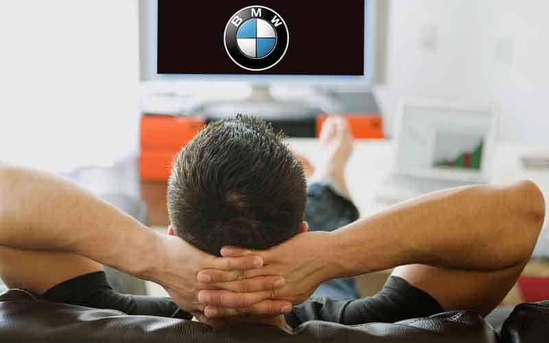 a guy watching a Super Bowl commercial for BMW