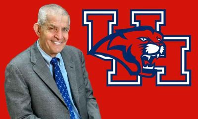 Mattress Mack in a suit in front of a Houston Cougars logo