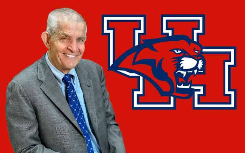 Mattress Mack in a suit in front of a Houston Cougars logo