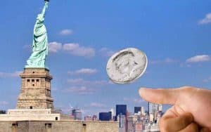 flipping a coin in the direction of the Statue of Liberty