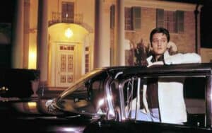 Elvis Presley getting out of a car in front of Graceland