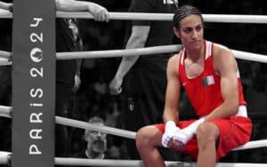 Imane Khelif sitting on the ropes of a boxing ring