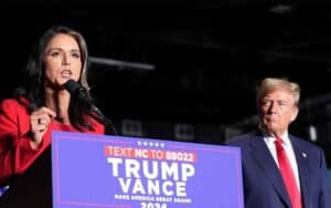 Tulsi Gabbard giving a speech with Trump watching