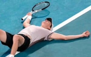 Jannik Sinner laying on the court at the Australian Open