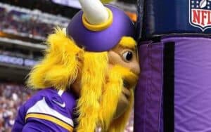 Minnesota Vikings mascot banging his head against the goalpost