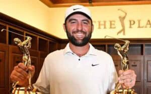 Scottie Scheffler holds his two trophies