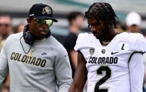 Deion and Shedeur Sanders talking on the sidelines