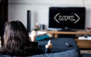a woman watching UFL on a TV
