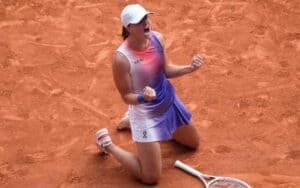 Iga Swiatek celebrating by falling to her knees on the clay courts of the French Open